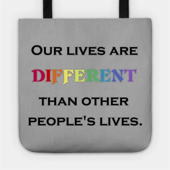 A tote bag with art text that reads Our Lives Are Different, with Different in rainbow letters.